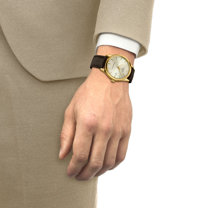 Tissot Classic Dream Powermatic 80 Gold PVD mit braunem Lederarmband, getragen am Handgelenk, Modell T1584073626100