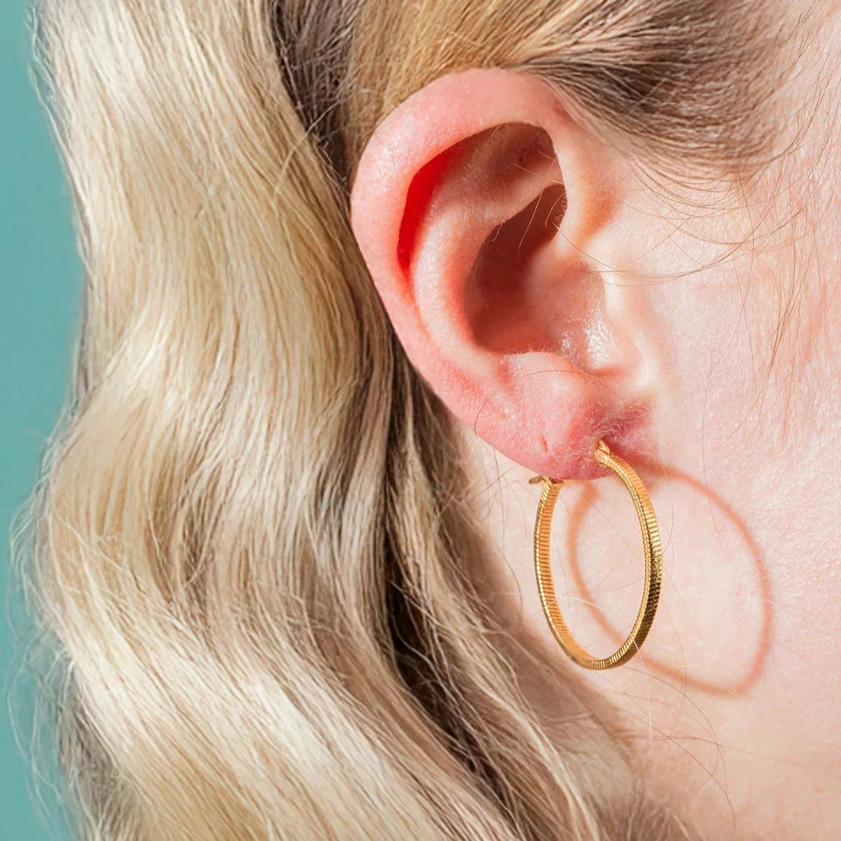 Vincent Fortune Teller vergoldete Kreolen-Ohrringe, groß, 25 mm, abgebildet am Ohr getragen, elegantes goldenes Kreolenmodell, Modell VJ078-UEG-L-1.