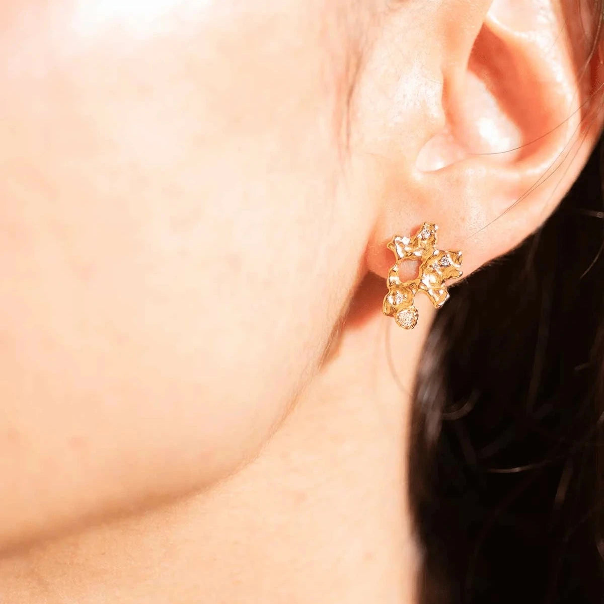 Vincent Ilium-Ohrringe vergoldet mit weißen Kristallen am Ohr, organische goldene Form. Modell VJ241-UEG-1.