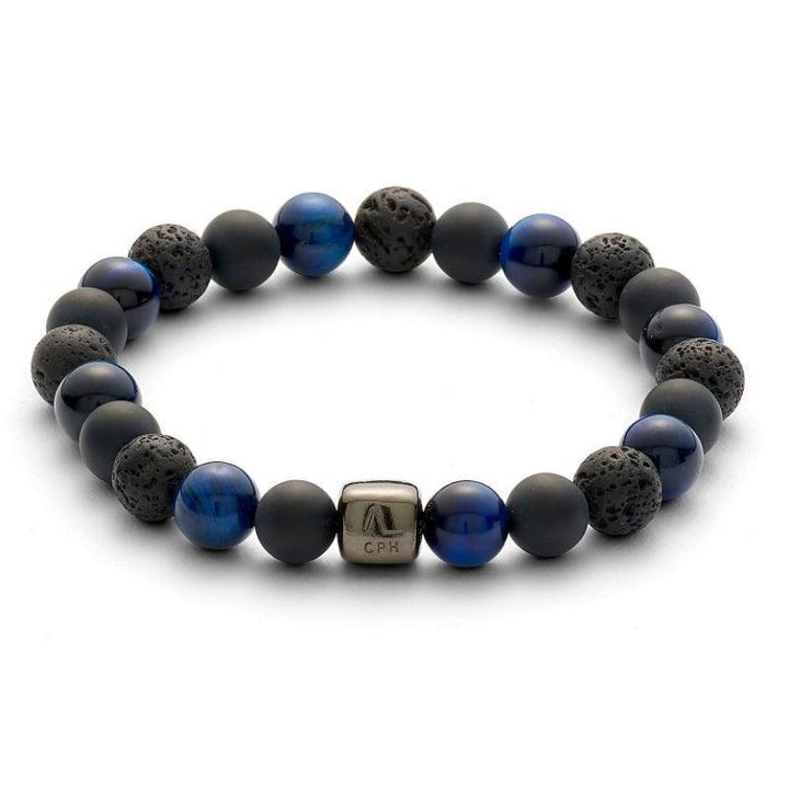 Das Alexander Lynggaard-Armband Paris 8 mm zeigt ein elastisches Armband mit schwarzen Lavaperlen und blauen Steinen. Modell c10113-001.