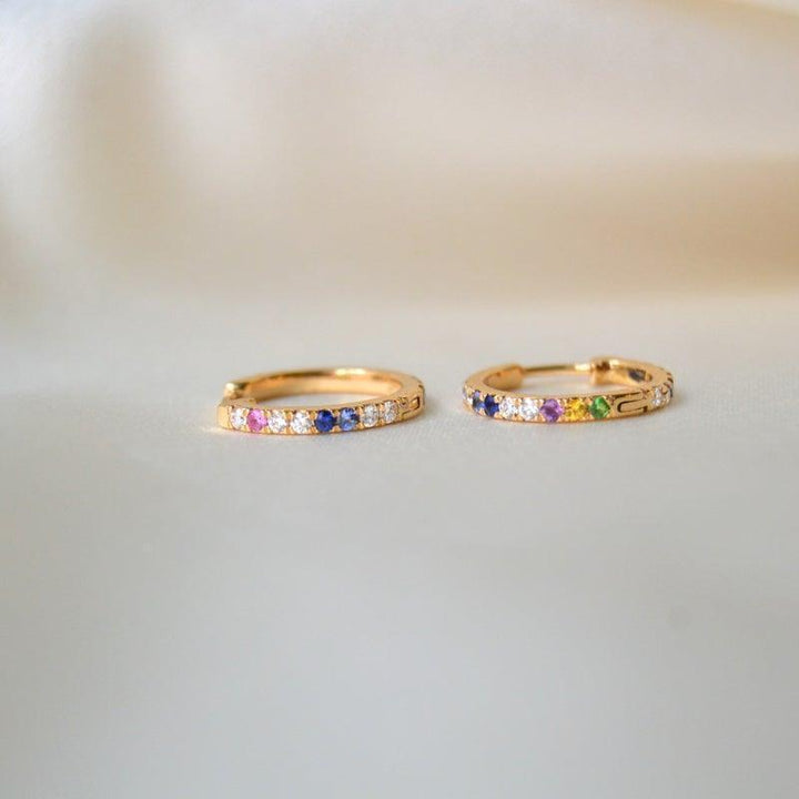 Anpe Atelier Kyra Creolen aus 18-karätigem Gold mit Brillanten und Edelsteinen, zwei Ohrringe mit farbigen Steinen auf hellem Hintergrund. Modell 23-2-customized-1