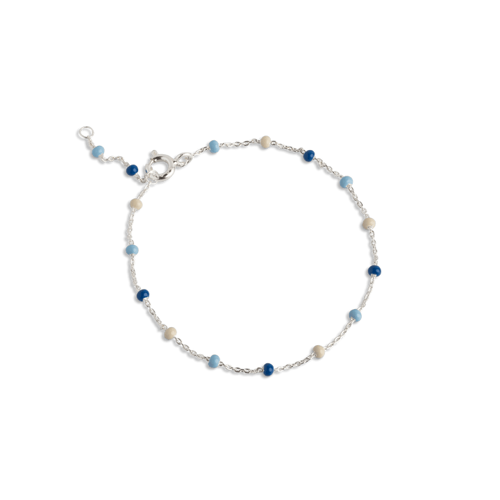 Enamel Lola Bracelet Marine zeigt ein skurriles Armband mit kleinen blauen und cremefarbenen Perlen, Modell b66s-marine-1.