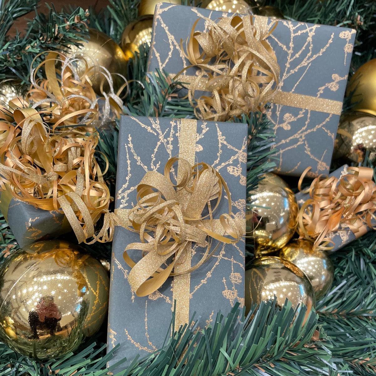 free-wrappping-weihnachtsgeschenke--1, Geschenkboxen aus dunklem Papier mit goldenen Bändern, umgeben von Weihnachtsdekorationen. Modell kostenlos-verpackende-weihnachtsgeschenke--1