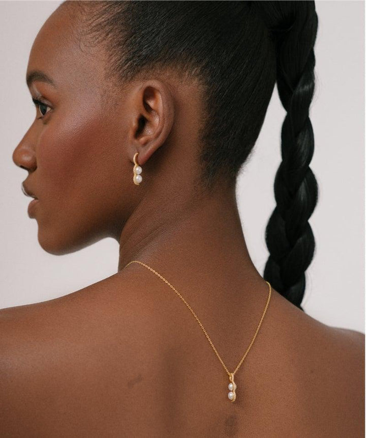 Herieth Paul x Polar Jewelry Bahati-Halskette, getragen vom Model, elegantes Gold mit Perlen. Modell BAH-NL-GD-WP-WZ-00503-2