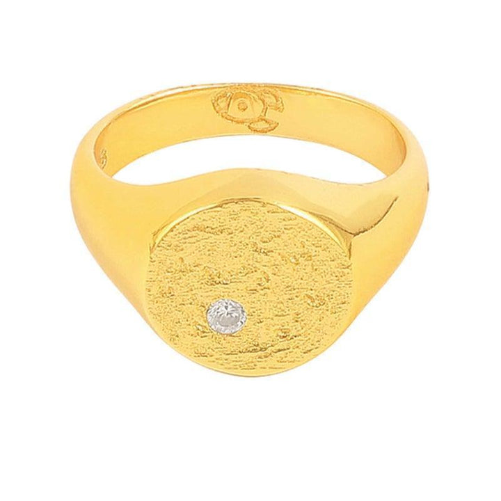 Hultquist Copenhagen Luna Ring S08116G zeigt einen goldfarbenen Ring mit einer runden, matten Oberfläche und einem klaren Stein. Modell S08116G-002-1