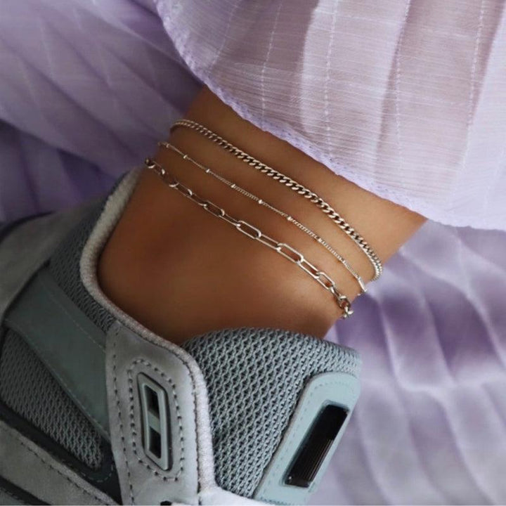 Jeberg-Jewellery-Nelly-Solv-Anklekaede in Silber ist am Knöchel mit Sneaker und hellviolettem Stoff zu sehen. Modell 4502-S