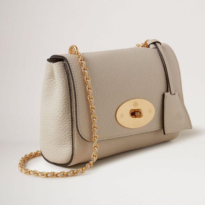 Mulberry Tasche Lily Chalk Heavy Grain zeigt eine elegante Umhängetasche aus hellgrauem, schwerem Leder mit Goldkette. Modell HH6950736W160