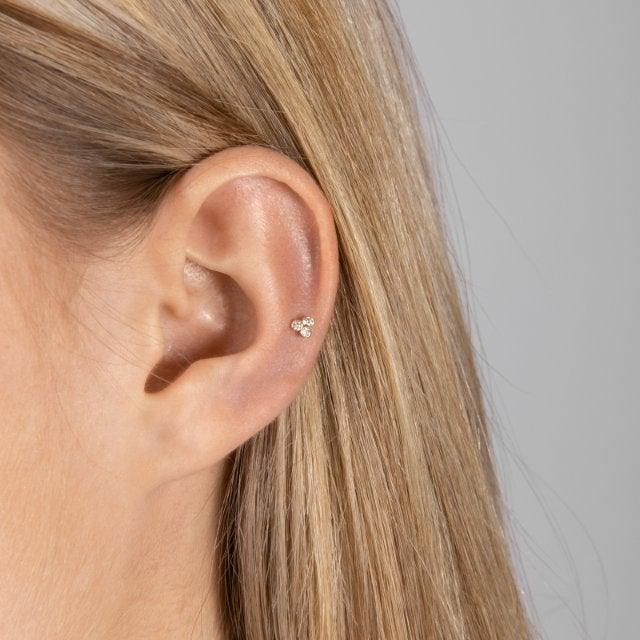 Nordahl 14kt Gold Piercing 0,04ct erscheint an einem Ohr mit hellem Haar, kleinem, elegantem Design. Modell 314007br5