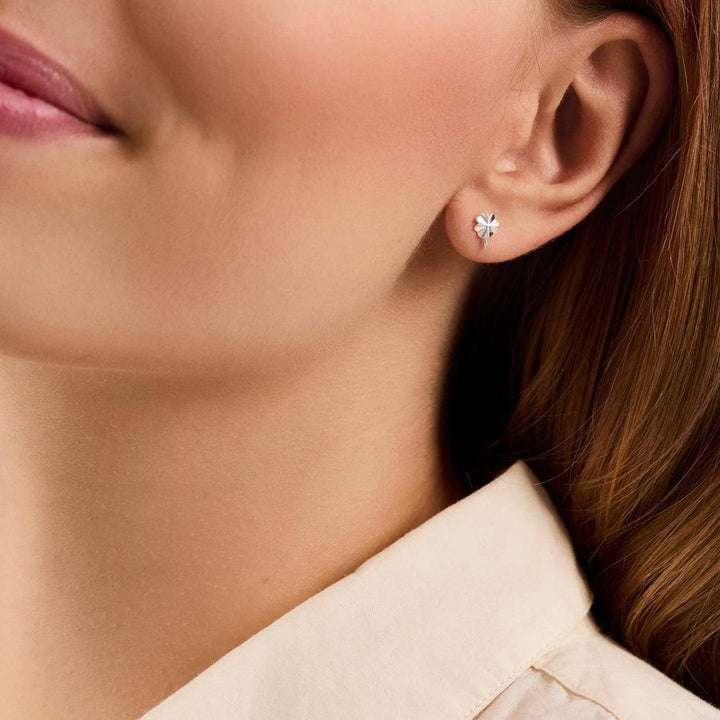 Pernille Corydon Clover Ohrringe am Ohr abgebildet, silberne Farbe und schlichter Stil. Modell E-320-S.
