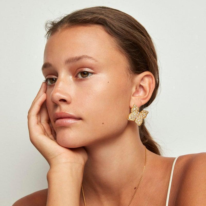 Polar Jewelry Der vergoldete Ohrring Butterfly erscheint am Ohr, großer goldfarbener Schmetterling mit Steinen, Modell TBU-ST-GD-WZ-00323