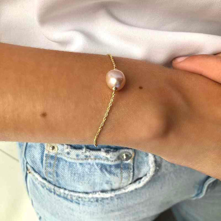 ro copenhagen Um das Handgelenk wird ein 18-karätiges Joy-Armband mit rosafarbenem Barock abgebildet, elegantes Goldarmband mit Perle. Modell 192l0013-002