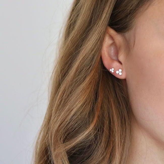 ro copenhagen Die Abbildung zeigt lustige Ohrstecker aus 18-karätigem Diamant, die am Ohr getragen werden, elegantes Design in Gold mit kleinen Diamanten. Modell 119280-2